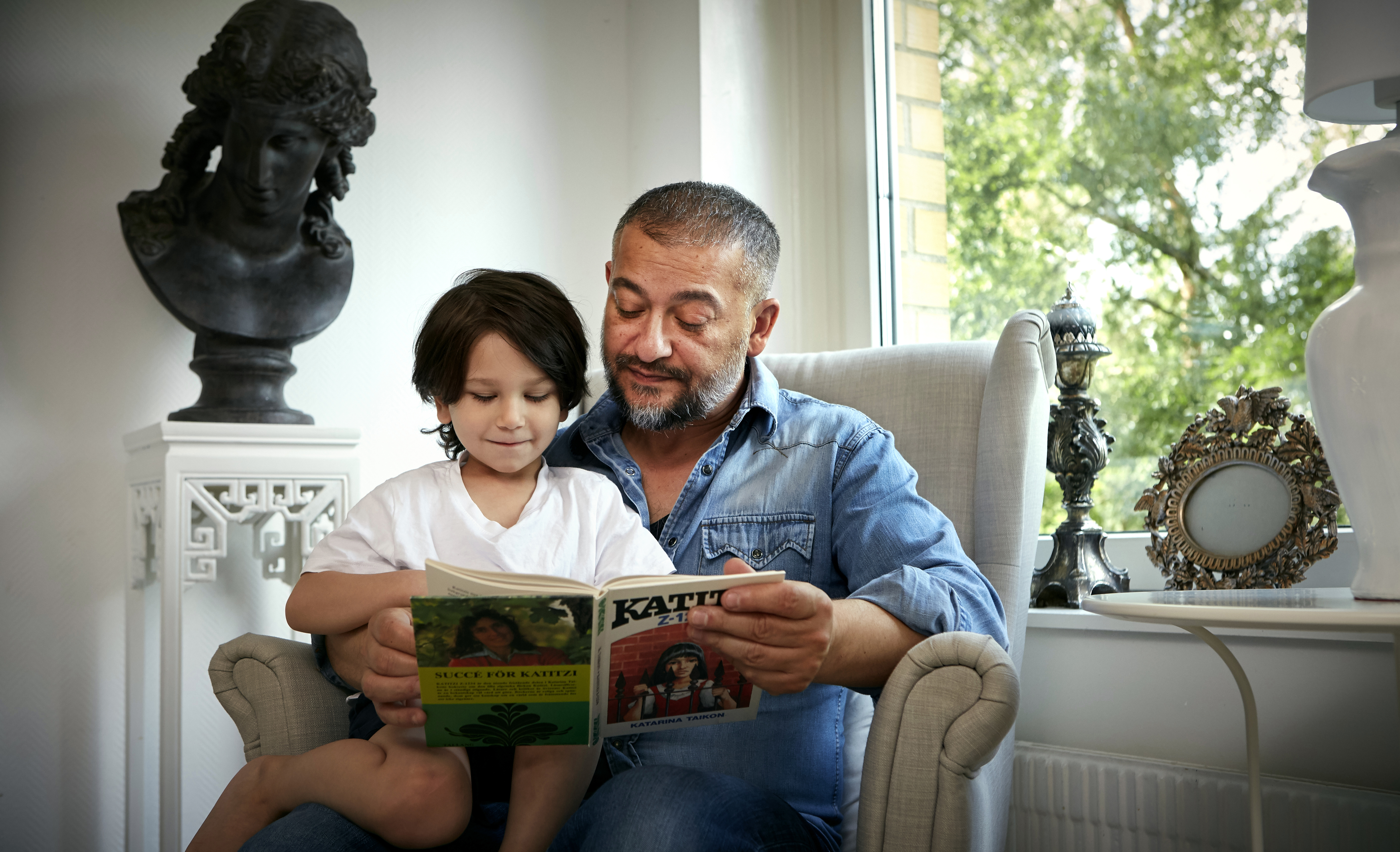 Läsambassadören Bagir Kwiek läser med sitt barn