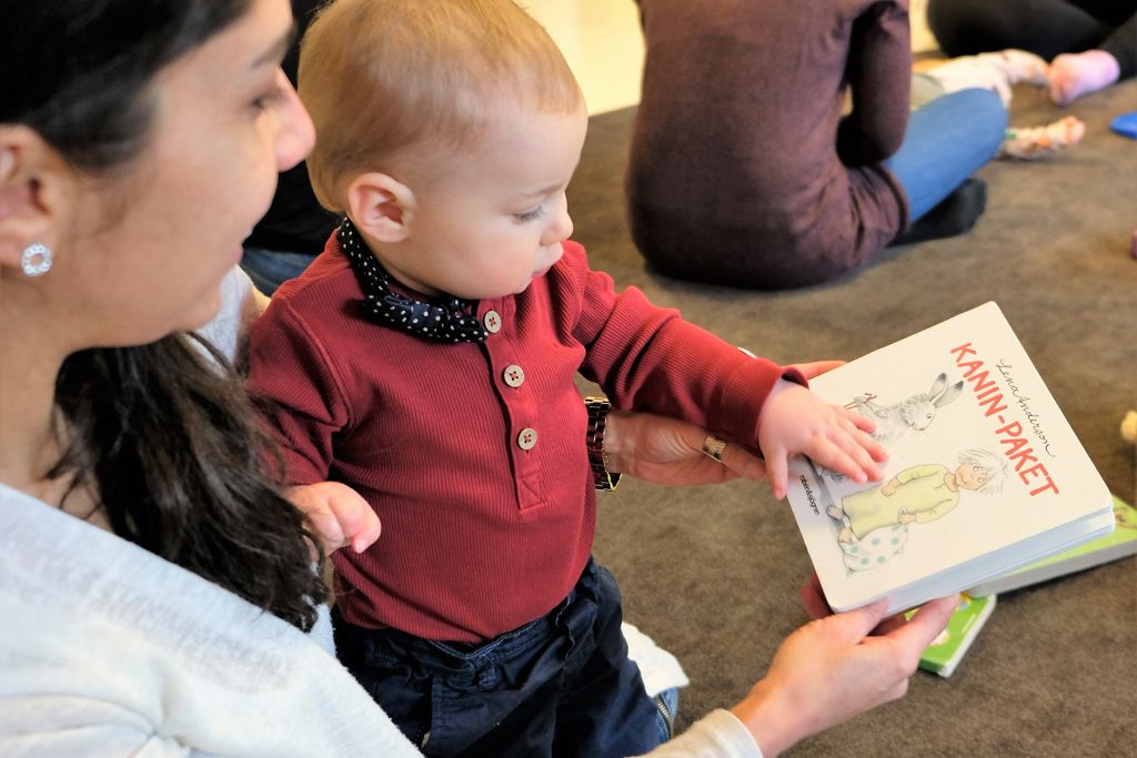 En vuxen ovch barn tittar i en bok tillsammans