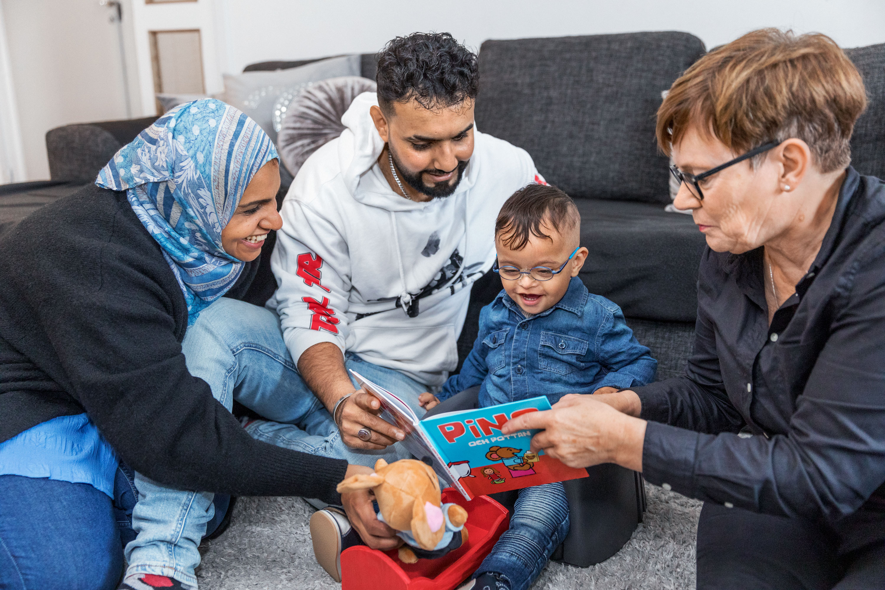 Ett hembesök från Bokstart i Norrköping som där bibliotekarien Margareta och familjen tillsammans läser och tittar i en bok.