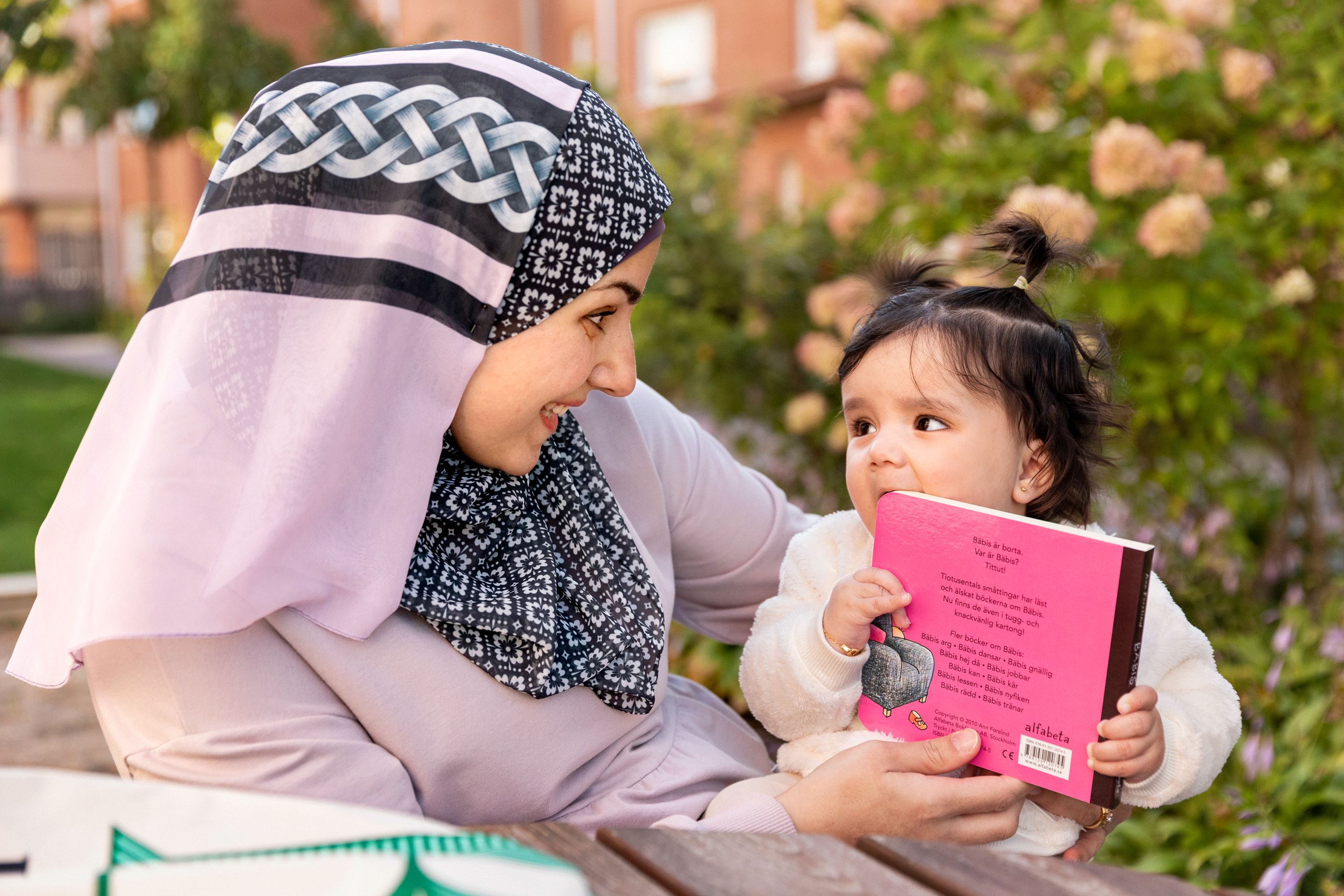 Vuxen kvinna läser tillsammans med ett litet barn.