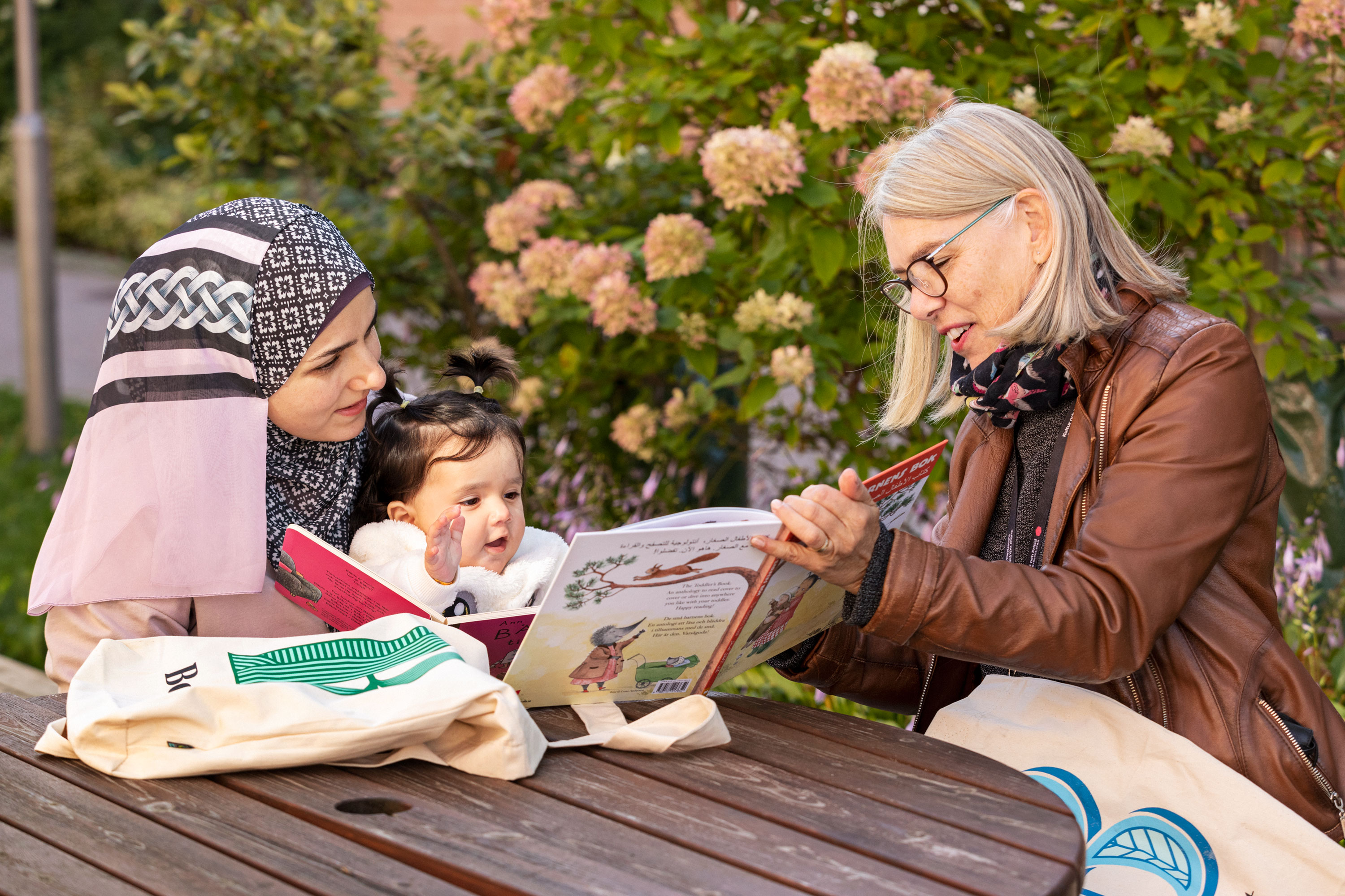 Vuxna läser tillsammans med ett barn under ett bokstartsbesök.