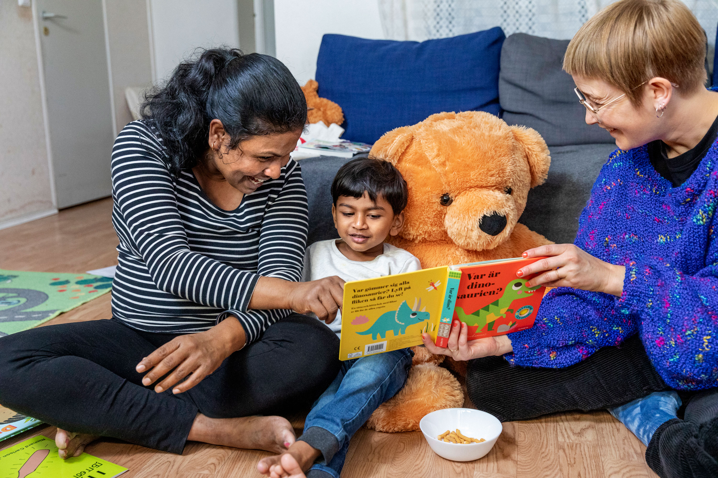 Vuxna läser tillsammans med barn. Foto:Susanne Kronholm.
