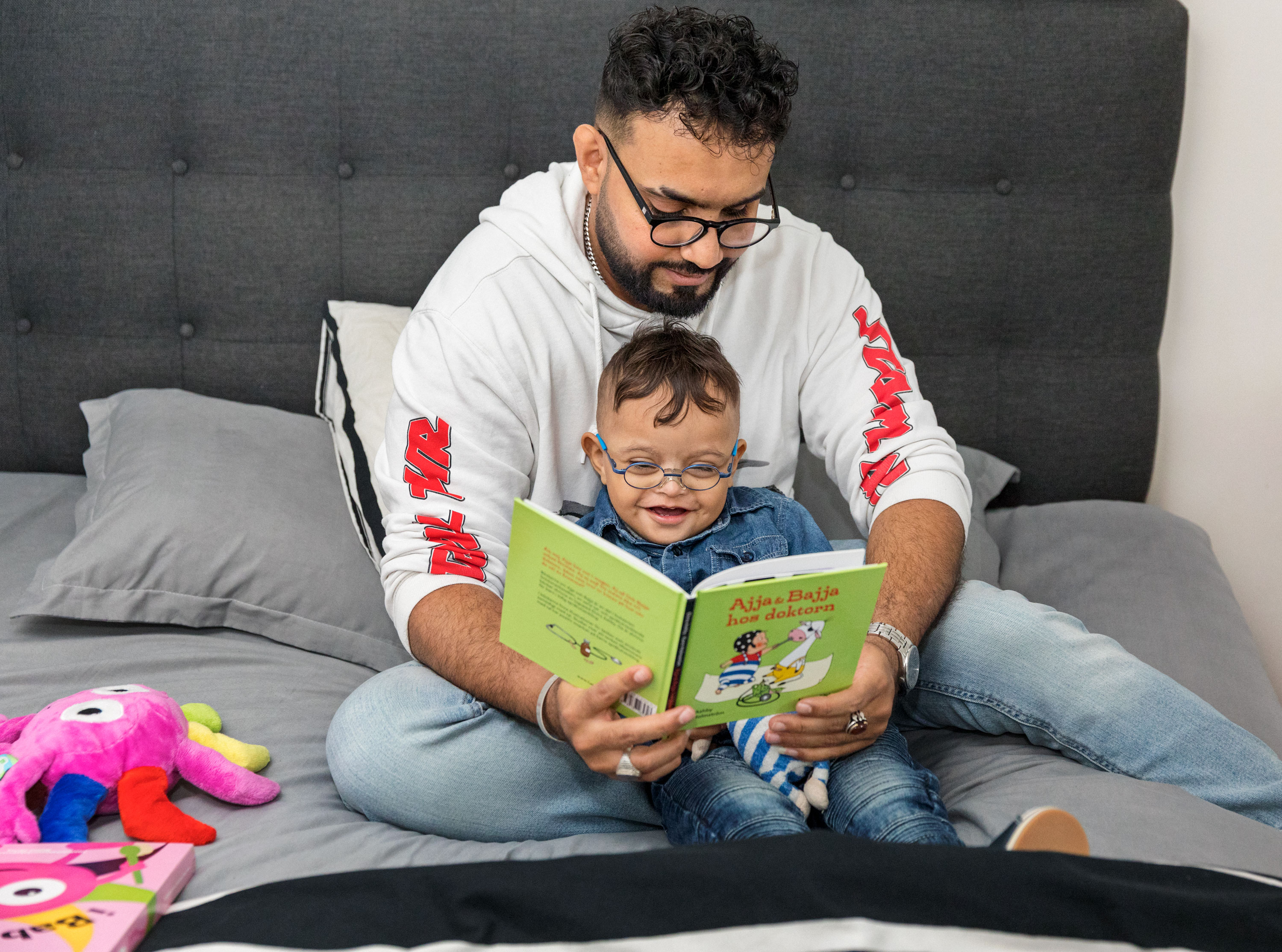Man läser en bok tillsammans med ett liten pojke