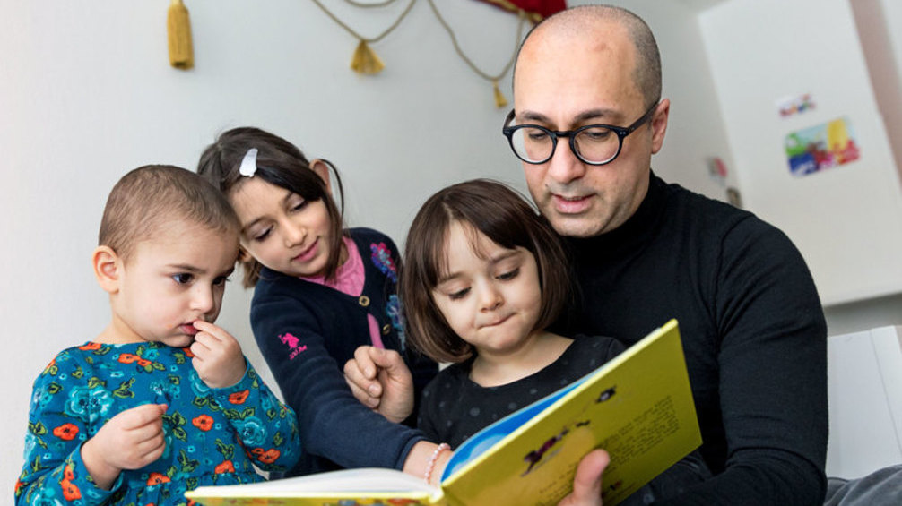En vuxen läser för tre barn